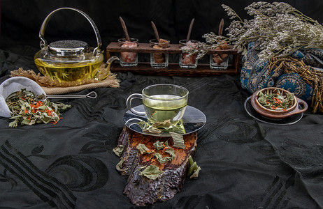 藏红花杯子摄影照片_一杯香兰叶茶，印度沼泽飞蓬植物叶与红花干（藏红花替代品）在深色背景下。