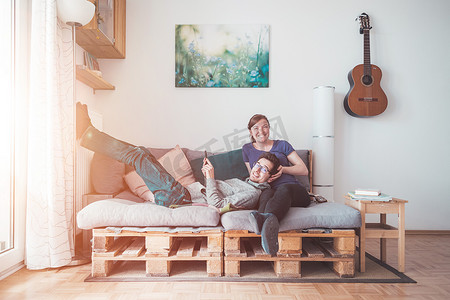 简单性摄影照片_简单的生活方式：夫妇坐在舒适的调色板沙发上，客厅