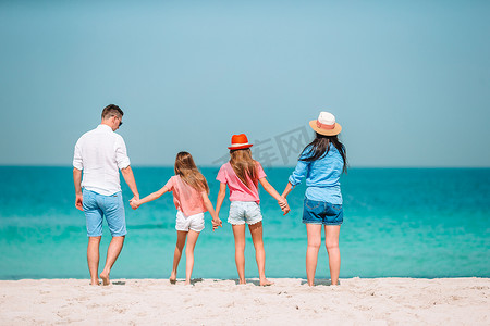 幸福的家庭在海滩上玩耍的照片。