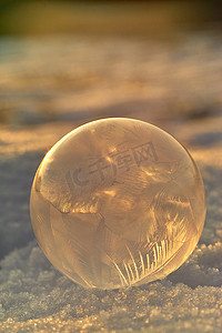 雪地上的冰冻气泡对着太阳