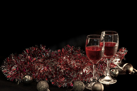 圣诞气氛，两个红酒杯在圣诞灯装饰背景下。