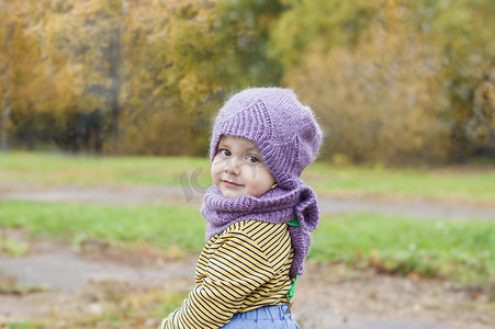 一个戴着紫色针织帽子和围巾的孩子。