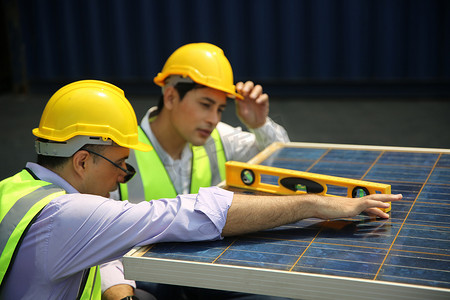 男工正在安装太阳能电池板，技术人员正在屋顶安装太阳能电池板。