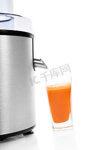 卡通榨汁机摄影照片_与榨汁机分离的新鲜胡萝卜汁。