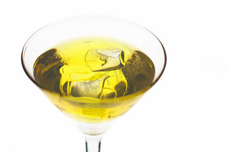 黄色鸡尾酒摄影照片_在马提尼酒杯中加冰的黄色鸡尾酒。