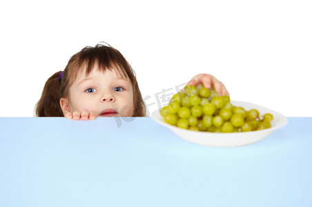 孩子伸手去拿桌上的葡萄