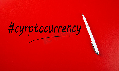 用标签符号和红色背景上的笔标记手写的加密货币一词。