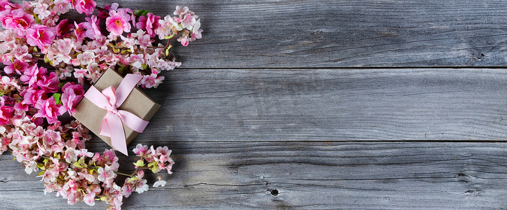 母亲节爱情假期风化木板上粉色樱花礼盒的顶部景色