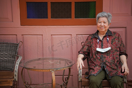 阳台人摄影照片_亚洲老年妇女老年女性在阳台露台上放松休息。