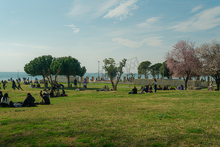 塞萨洛尼基，希腊三月 不明身份的人群在海滨前的公园里。