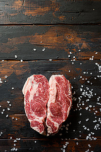 Heartshape Raw Chuck Tenders 在老式深色木桌有机牛肉上卷牛排。