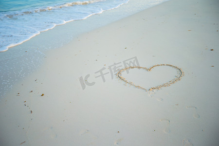 平静的心摄影照片_在热带海滩上用白色沙子画的心