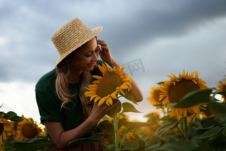 站在农业向日葵田里的女农艺师白种人女农民草帽肖像农业综合企业工人