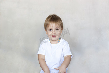 一个穿着白色 T 恤的可爱小男孩的画像。