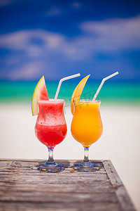 令人惊叹的绿松石海背景中的两杯鸡尾酒新鲜西瓜和芒果