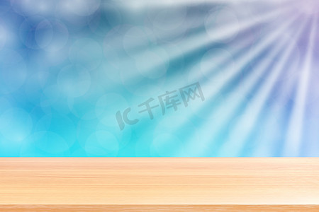 空木桌地板上柔和的蓝色散景灯光束闪耀渐变背景，蓝色散景上空的木板彩色灯光闪耀，彩色散景灯渐变柔和，用于横幅广告