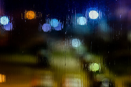 抽象背景夜路灯透过湿玻璃散景，特写有选择的焦点