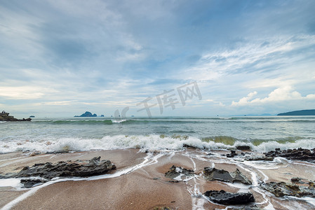 海的字体摄影照片_泰国沙滩上的尖石和海泡沫