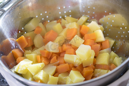 胡萝卜土豆摄影照片_土豆和胡萝卜切成方块蒸熟