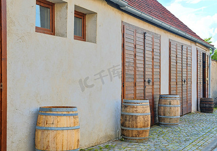 白酒现代摄影照片_在现代酒窖前面的老土气酒桶。