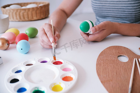 女人在家里画复活节彩蛋。