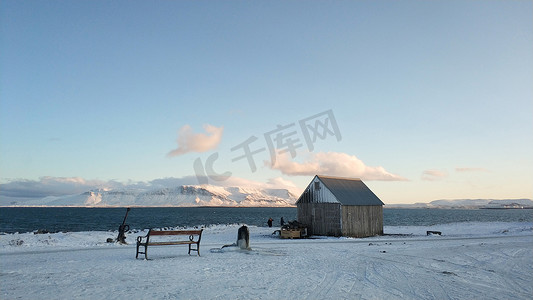 下雪别墅摄影照片_冰岛冬季孤独的海滨别墅，享有山景。