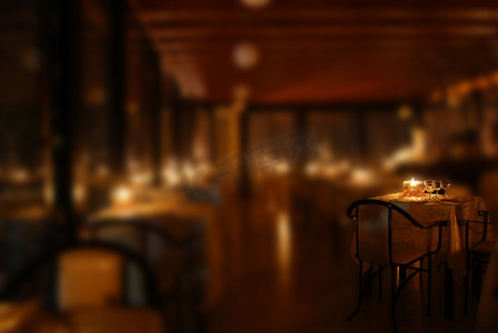昏暗的餐厅摄影照片_在烛光下布置餐厅的桌子