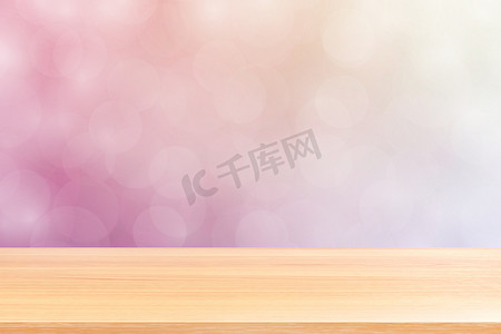 空木桌地板在模糊的散景柔和的粉红色渐变背景上，木板空在粉红色散景彩色浅色阴影上，彩色散景灯渐变柔和，用于横幅广告产品