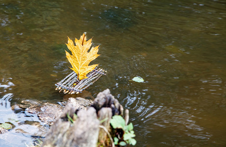 带帆的玩具筏漂浮在湖面上