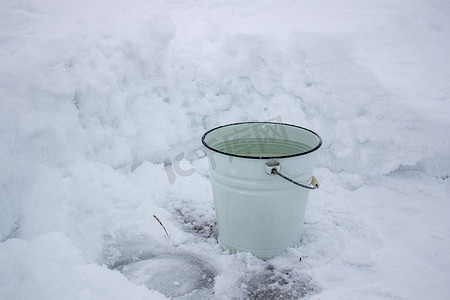 一桶水在寒冷的白雪上。