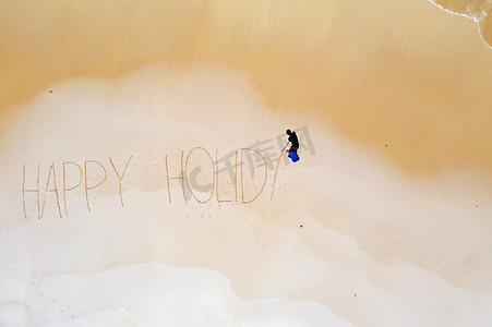 从海浪中拍摄的空中顶部和手写的“快乐假期”