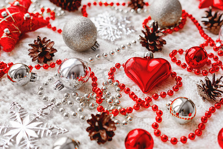 圣诞节和新年背景与装饰-球、星星、银色闪闪发光的雪花、带有装饰图案的针织面料上的心。