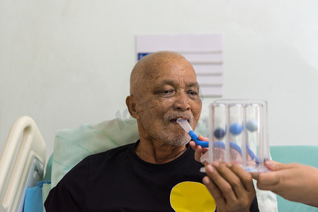 长辈鼓励摄影照片_病人在医院使用激励肺活量计