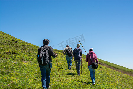 徒步背景摄影照片_背着背包和登山杖在阿尔特文高地行走的徒步旅行者