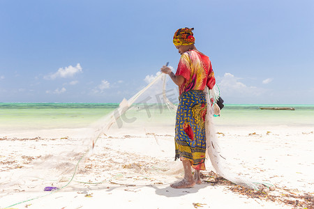 捕鱼女摄影照片_坦桑尼亚桑给巴尔帕杰海滩上的传统非洲当地乡村捕鱼。