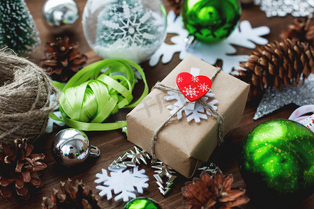 圣诞节和新年背景与木制背景上的礼物、丝带、球和不同的绿色装饰品。