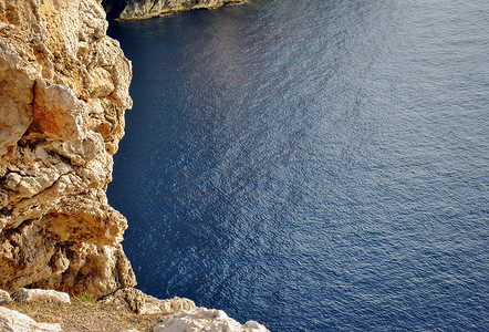 俯瞰水摄影照片_俯瞰蓝色平静海面的岩石海岸线