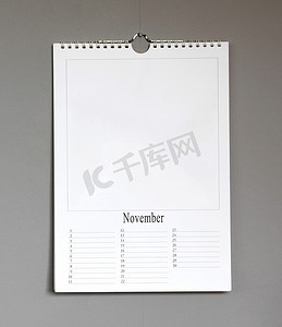 挂机摄影照片_挂在灰色墙上的简单旧生日日历 — 11 月