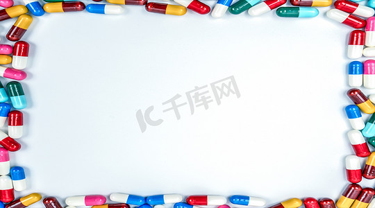 五颜六色的抗生素胶囊药丸矩形框架在白色背景与复制空间。