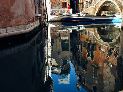 船在水中倒影摄影照片_意大利威尼斯的房屋及其在水中的倒影