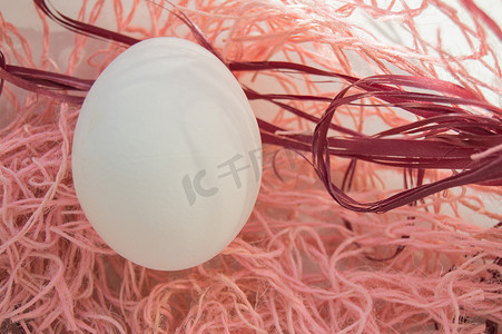 鸟巢背景图摄影照片_复活节概念，粉红色背景中的白蛋，编织织物巢，顶视图，复制空间，阳光