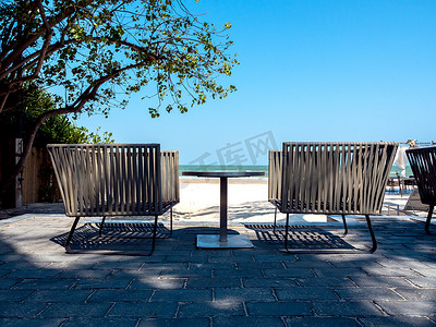 海景摄影照片_海景阳台上带边桌的现代椅子。