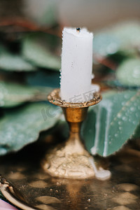 婚礼背景板摄影照片_婚礼装饰的蜡烛和绿叶与雨滴
