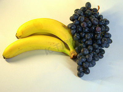 一束成熟、美味的香蕉、三片和一串葡萄。