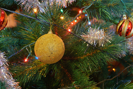 金色灯光背景摄影照片_树上的圣诞球，有灯光和星星