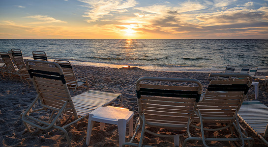 墨西哥湾沿岸摄影照片_佛罗里达州那不勒斯范德比尔特海滩沿岸的椅子
