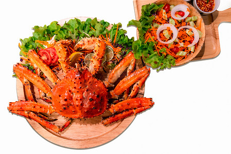 螃蟹蔬菜摄影照片_煮熟的阿拉斯加帝王蟹配蔬菜沙拉，背景为白色。