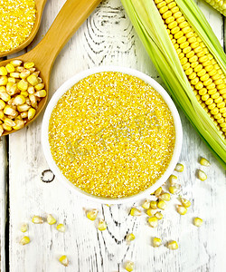 勺子黄色摄影照片_碗里的玉米糁，上面有玉米棒子