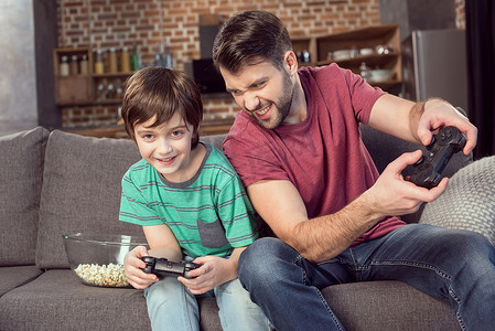 快乐的父子在家玩电子游戏