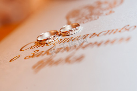 金色的结婚戒指背景与金色的会标。